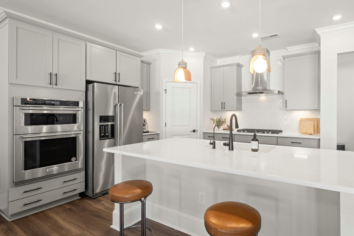 Wood kitchen cabinetry with modern white countertops
