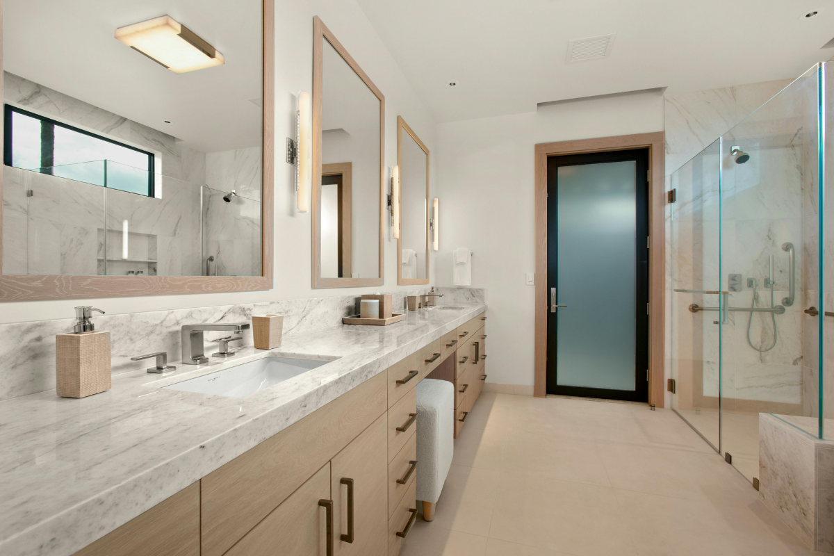 Modern primary bathroom with double vanity and glass shower