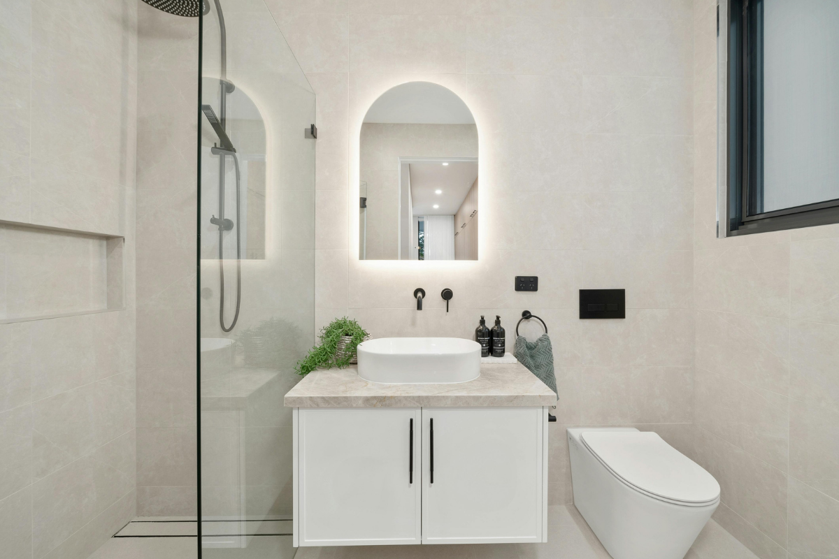 Spa-inspired bathroom with arched mirror and walk-in shower